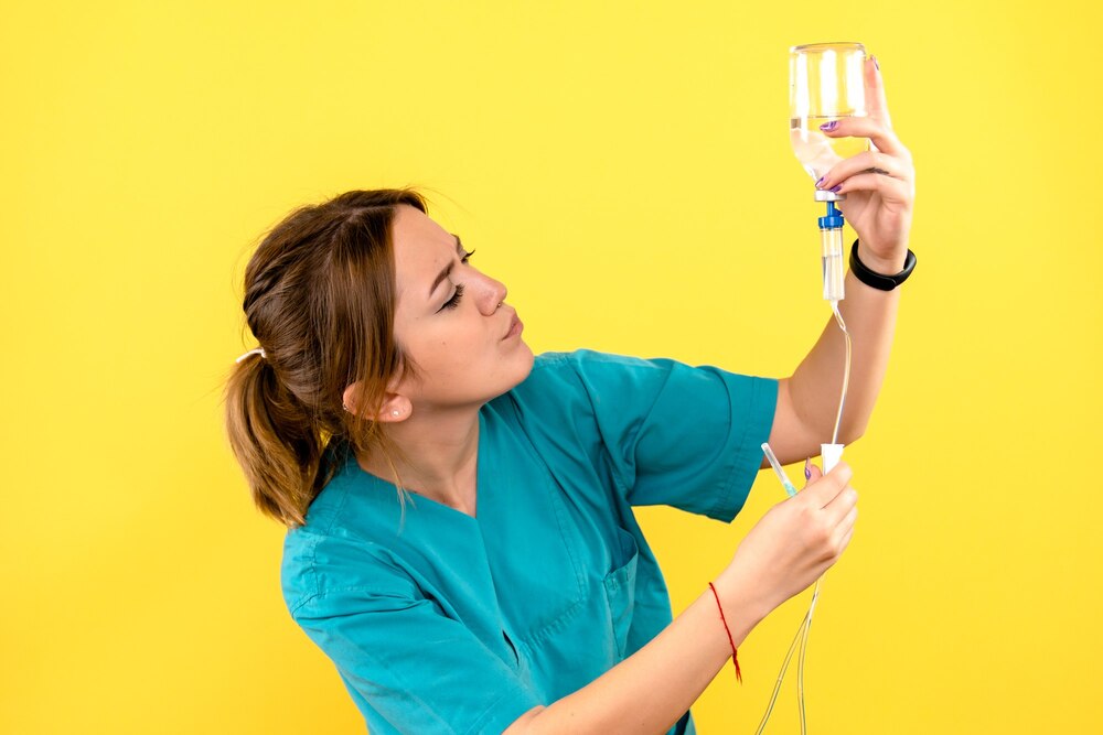 Front view of female veterinarian holding dropper on yellow wall