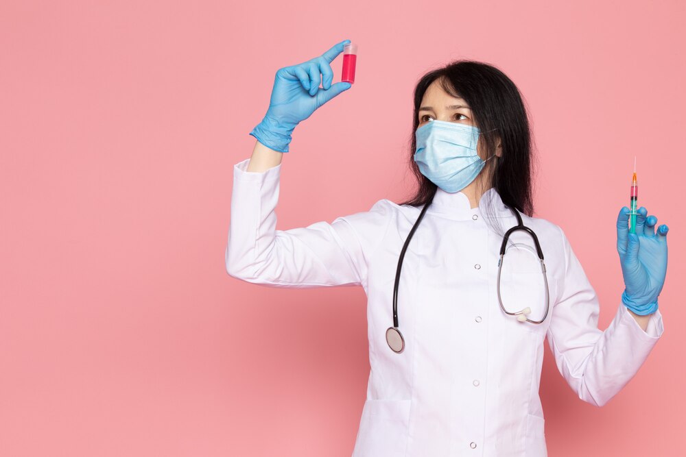 young woman in white medical suit blue gloves blue protective mask on pink